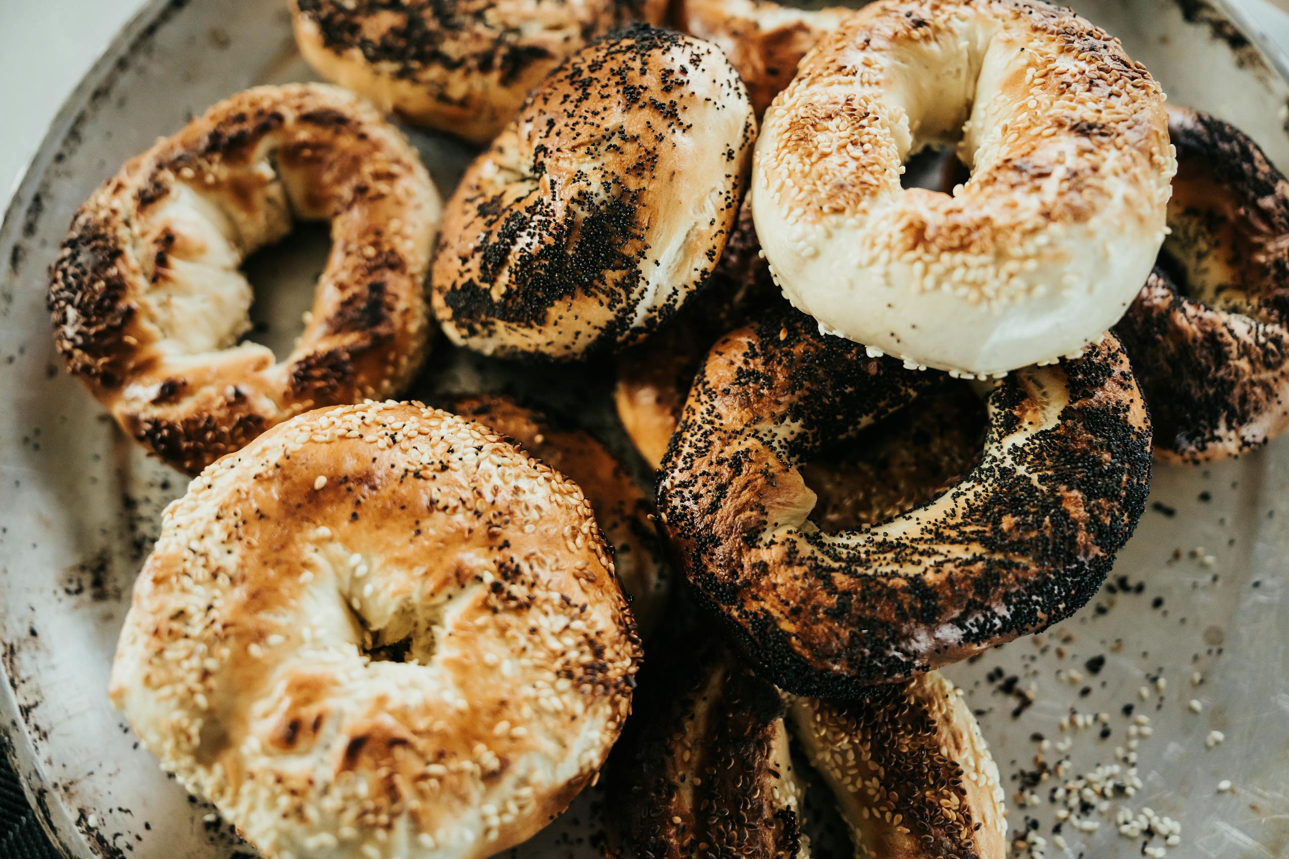 Delicious assortment of poppy and sesame seed bagels on a rustic platter.